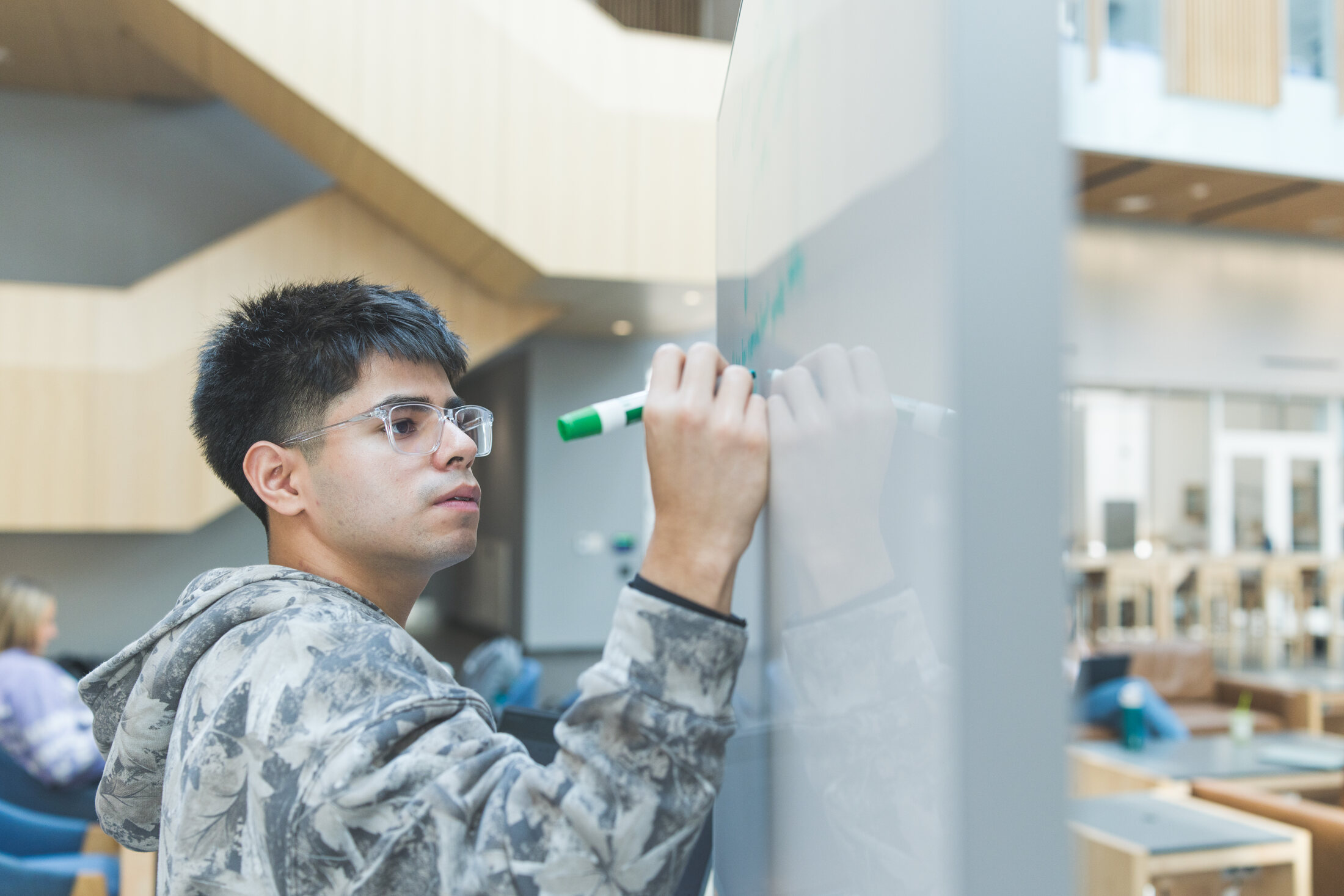 An Evergreen student sketching ideas on a whiteboard during a working session