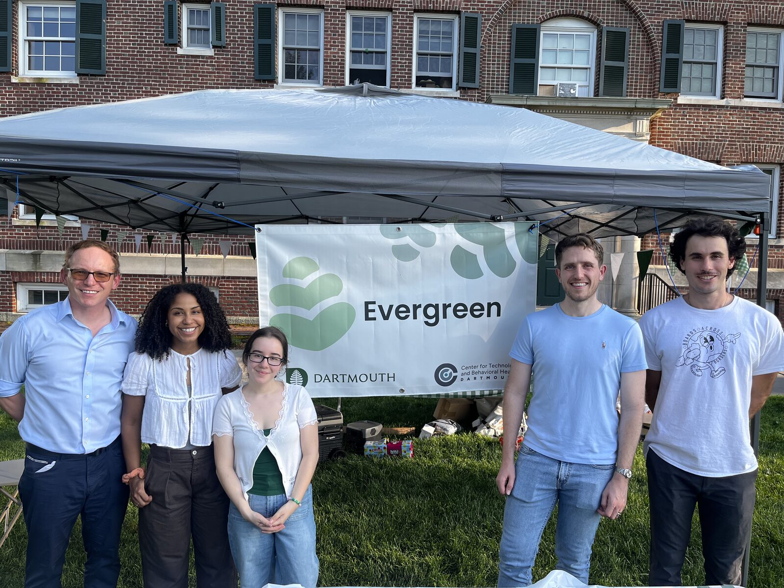 A group of Evergreen team members with the project banner at a campus event