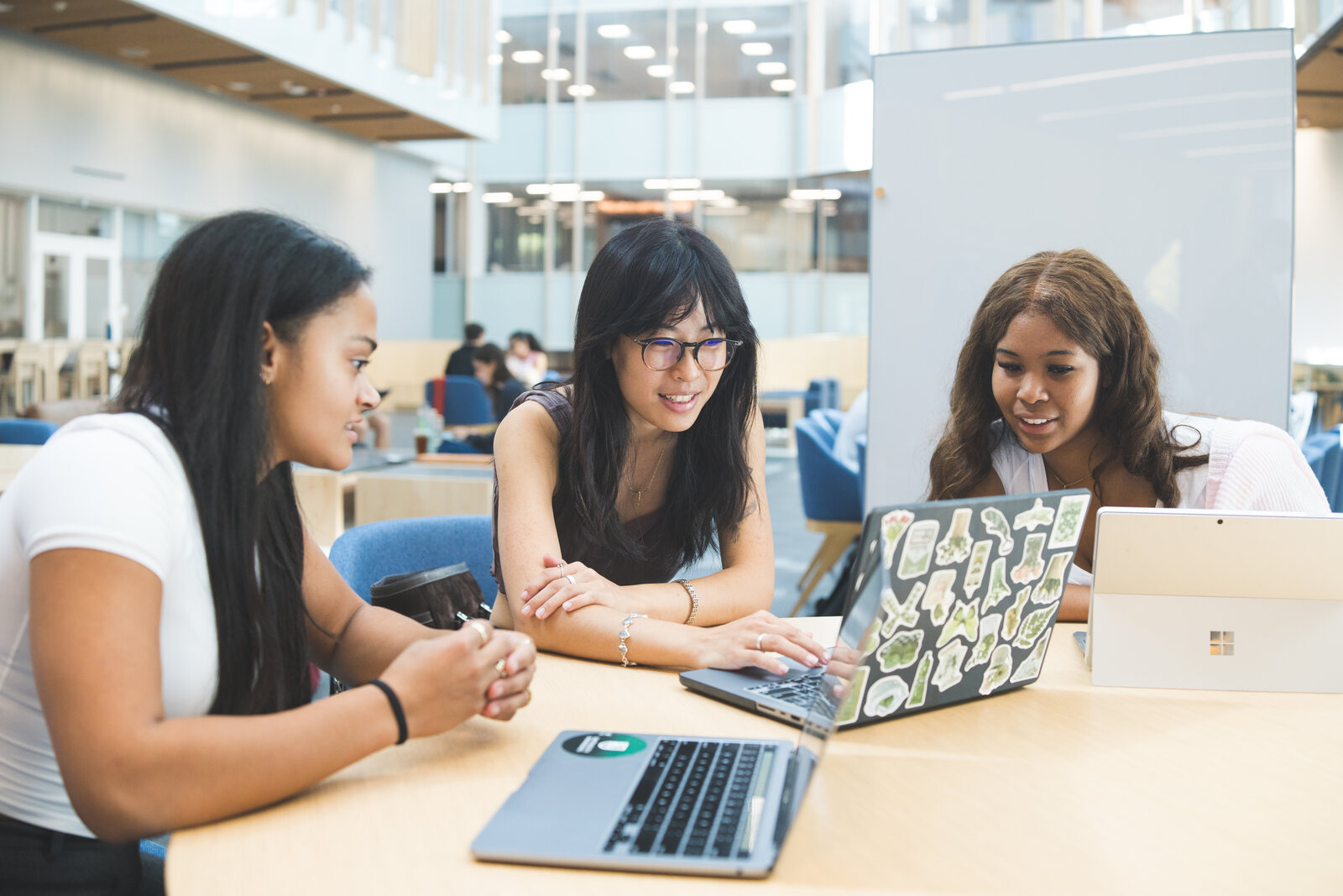 Three Evergreen students talking through ideas at a table during a working session