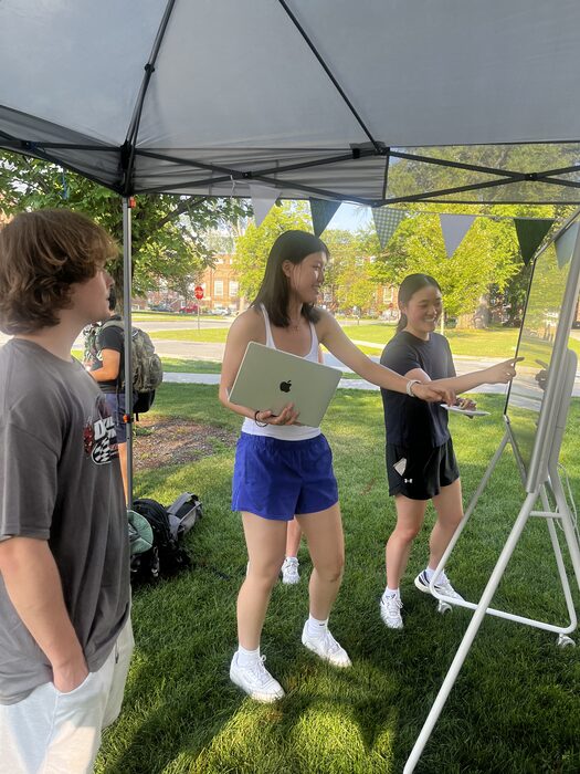 Students sharing a laptop outdoors at an Evergreen event