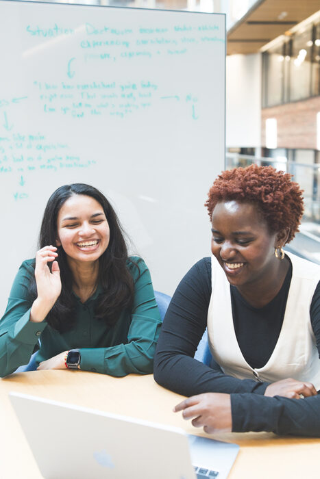 Two Evergreen students laughing together during a working session