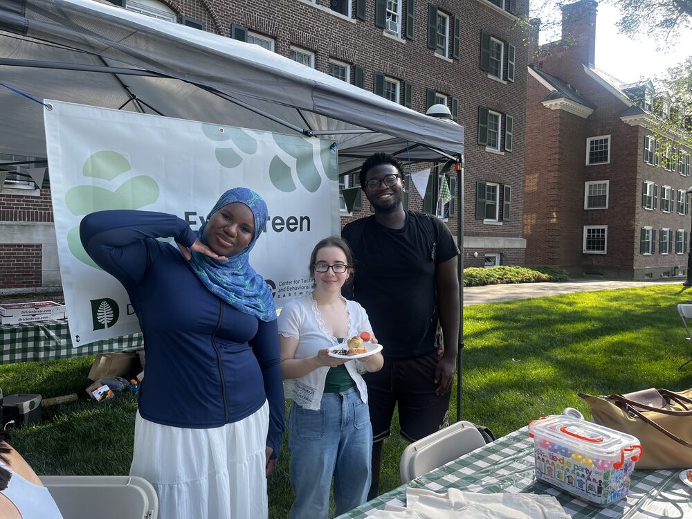 Three smiling team members at the Evergreen tent